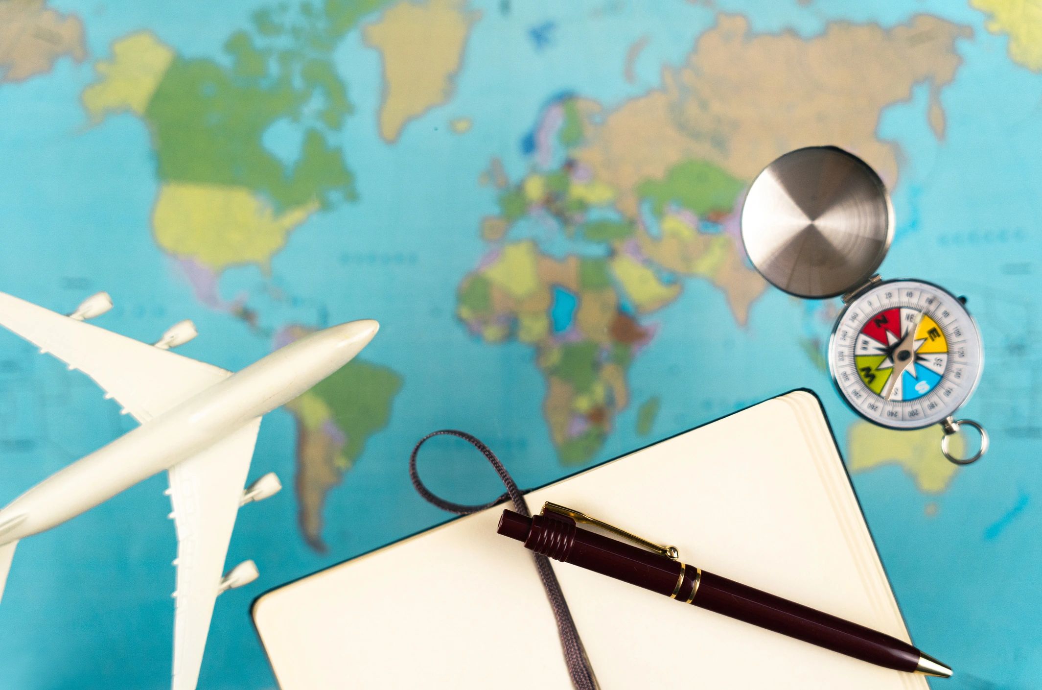 World map with travel planning items on a desk