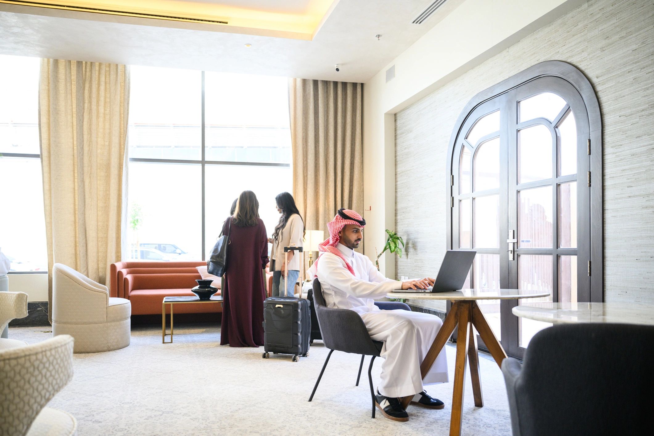 International professionals working on laptops in a modern travel setting